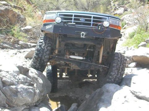 1994 Ford Bronco - This modified Ford Bronco is shown from the front, tackling a challenging off-road course.