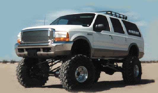 White lifted SUV with large tires and roof rack. Text on rear window reads 'EXCURSION'