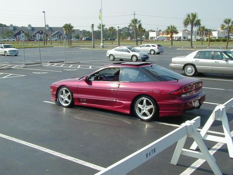 1994 Ford Probe - A red 1994 Ford Probe GT is parked in a lot, showing its distinctive body style and aftermarket wheels.