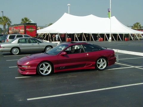 1994 Ford Probe - Red 1994 Ford Probe GT with aftermarket wheels parked in a lot.