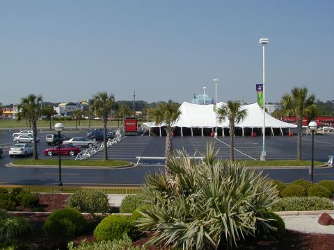 1994 Ford Probe - A red sports car is visible in a parking lot near a large tent structure.