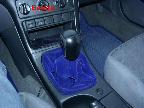 1995 Ford Probe - The interior of a car features a blue velvet shifter boot and a black shift knob, with dashboard controls visible.