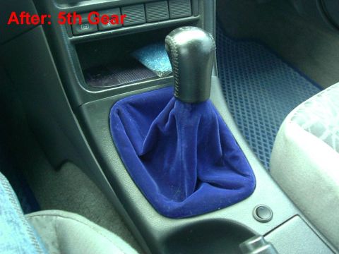 1995 Ford Probe - Close-up of a car's interior showing a gear shifter with a blue velvet boot and a leather shift knob.