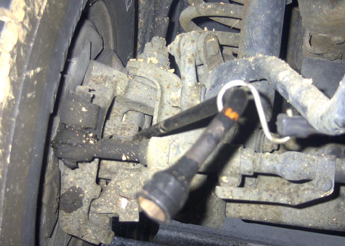 As I was doing this project "Lone Ranger" style, I needed to apply outward pressure
on the axle shaft u-joint. The only way I could quickly resolve this was to place a
standard crow bar behind the u-joint and using a black rubber tie-down strap to
pull tension on the crow bar. I simply hooked the other end to the Pittman arm