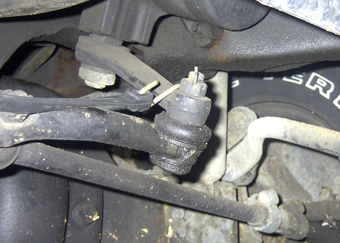 As I was doing this project "Lone Ranger" style, I needed to apply outward pressure
on the axle shaft u-joint. The only way I could quickly resolve this was to place a
standard crow bar behind the u-joint and using a black rubber tie-down strap to
pull tension on the crow bar. I simply hooked the other end to the Pittman arm