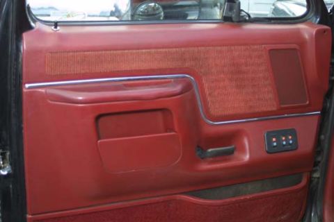 1989 Ford Bronco - Interior door panel of a 1989 Ford Bronco, showing red upholstery and trim details.