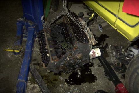 1989 Ford Bronco - A pulled V8 engine block sits on a shop floor with the intake manifold removed, exposing both cylinder heads' valve springs, pushrods and l…