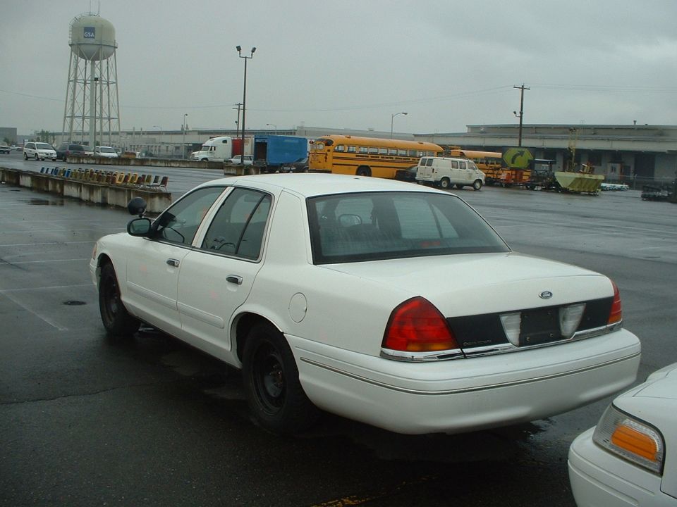 White sedan with black trim on the rear, parked on wet asphalt