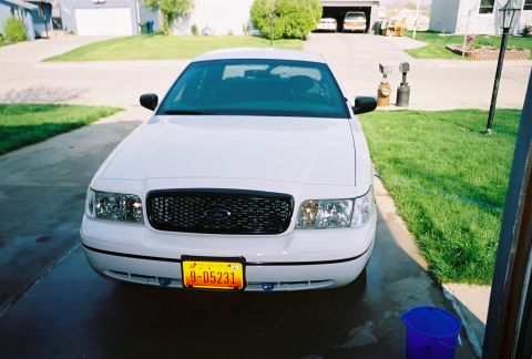 2000 Ford Crown Victoria - A white 2000 Ford Crown Victoria is parked in a driveway, facing the camera.