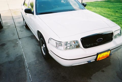2000 Ford Crown Victoria - A white 2000 Ford Crown Victoria is parked on a concrete driveway with green grass in the background.