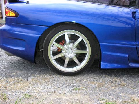 1994 Ford Probe - Close-up of the rear wheel and fender of a blue 1994 Ford Probe with aftermarket rims.