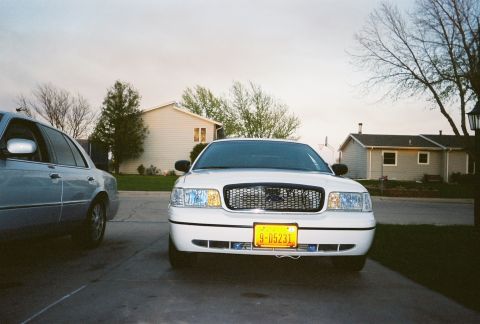 2000 Ford Crown Victoria - Front view of a white 2000 Ford Crown Victoria parked next to another vehicle.