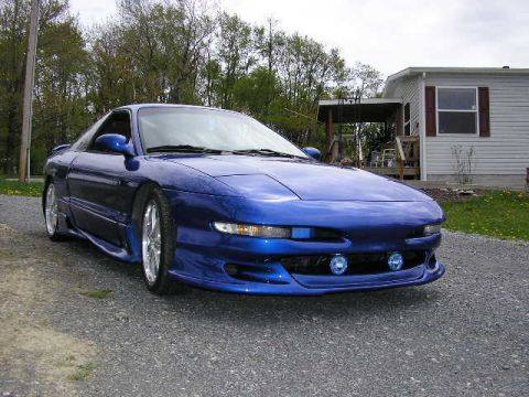 1994 Ford Probe - A blue 1994 Ford Probe is parked in front of a mobile home.