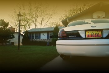2000 Ford Crown Victoria - A white sedan is parked in front of a house on a sunny day. The license plate is visible.