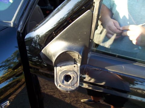 2003 Ford Ranger - The side mirror assembly of a black vehicle is shown detached from the door.