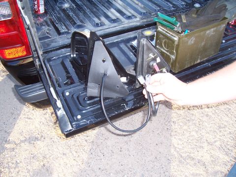 2003 Ford Ranger - Two side mirrors are laid out in the bed of a black pickup truck next to a green ammo can filled with tools.