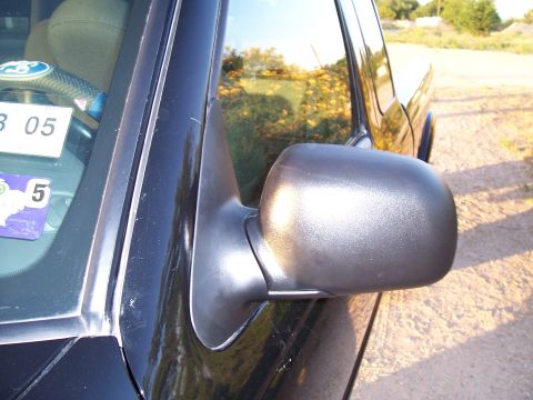 2003 Ford Ranger - Side mirror and windshield frame detail on a vehicle, with a sticker showing '3 05'.