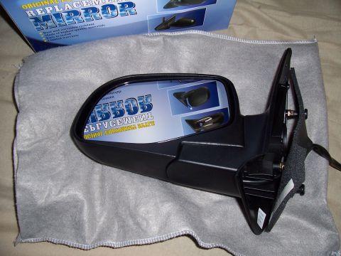 2003 Ford Ranger - A new replacement side mirror is displayed with its packaging, which indicates it is a direct fit part.