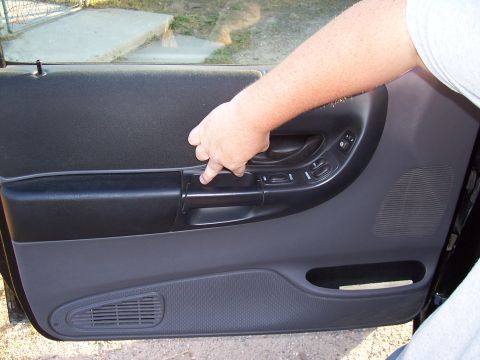 2003 Ford Ranger - Close-up of a vehicle's interior door panel, showing the door handle and window controls.