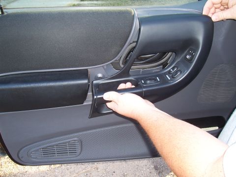 2003 Ford Ranger - Hand operating window controls on the interior door panel of a 2003 Ford Ranger.