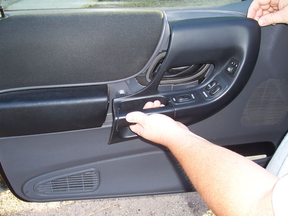 2003 Ford Ranger interior door panel with hand on handle and window controls