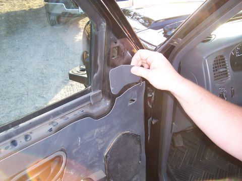 2003 Ford Ranger - A hand is shown placing an insulation panel inside the door panel of a vehicle.