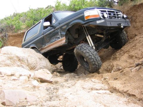 1994 Ford Bronco - Ford Bronco navigating a difficult rocky obstacle during an off-road excursion.