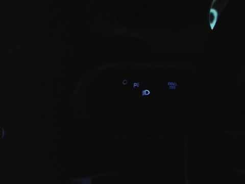 1999 Ford Taurus - The interior of a car at night shows illuminated control buttons for lights and panel dimming.