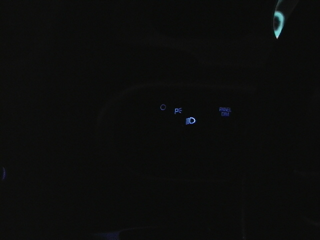 Car dashboard lights showing parking lights, headlights, and panel dim controls