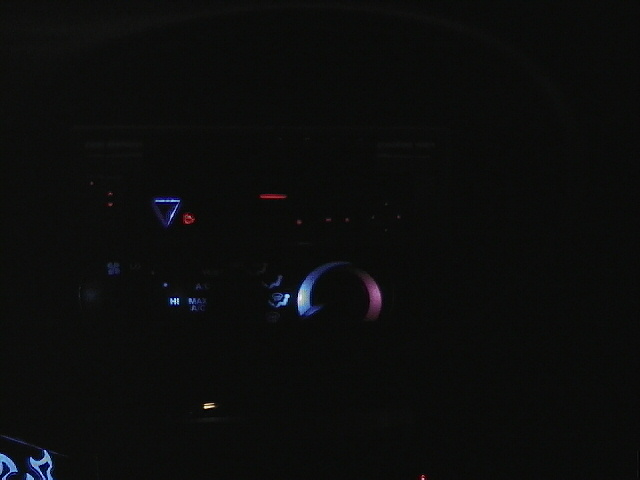 Car dashboard with illuminated climate controls and a digital display showing '7'