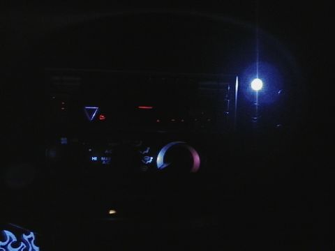 1999 Ford Taurus - Interior view of dashboard controls with illuminated buttons and knobs.