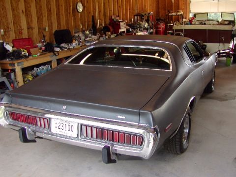 1988 Ford Bronco - The rear of a classic Dodge Charger is parked in a workshop, showing its distinctive taillights and chrome bumper.