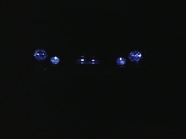 Darkness obscures vehicle; headlights visible