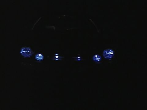 1999 Ford Taurus - Close-up of two vehicle headlights against a dark backdrop.