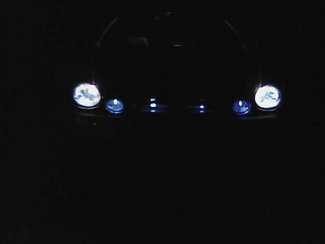 Headlights and grille of a car at night