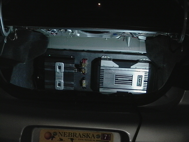 Car stereo system with a digital display and buttons, installed in a dark car interior