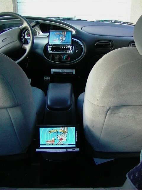 1999 Ford Taurus - The interior of a 1999 Ford Taurus features two screens, one on the dash and one in the center console, both displaying Looney Tunes cartoo…