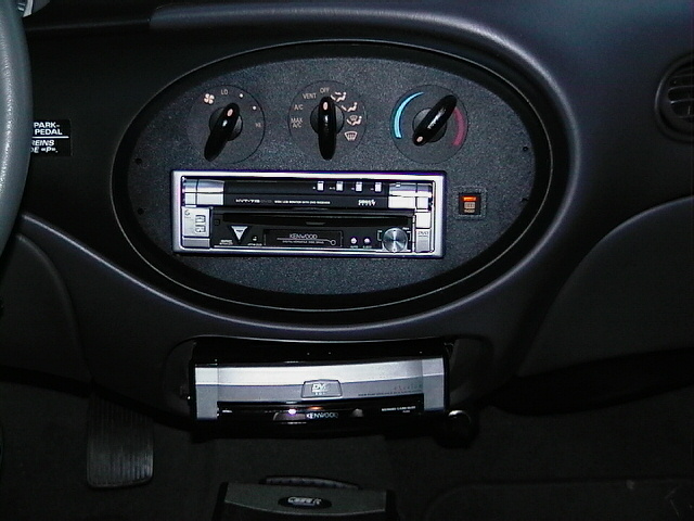 Car interior dashboard with aftermarket Kenwood stereo and DVD player installed