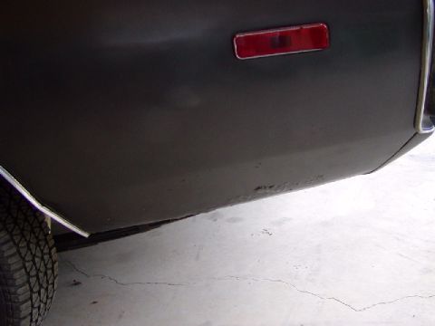 1988 Ford Bronco - Rear quarter panel detail showing rust and a red reflector light.
