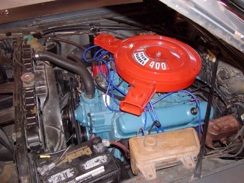 1988 Ford Bronco - Close-up of an engine bay a blue engine block and a prominent red air cleaner assembly with "400 FOUR BARREL" text.