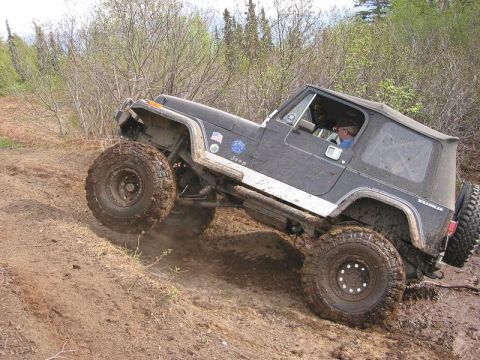 1985 Ford Bronco - Rick Lifting a wheel trying to get up small hill.
