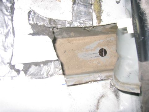 1997 Jeep Cherokee - Close-up view of the interior of a vehicle's chassis, revealing exposed metal and insulation materials.