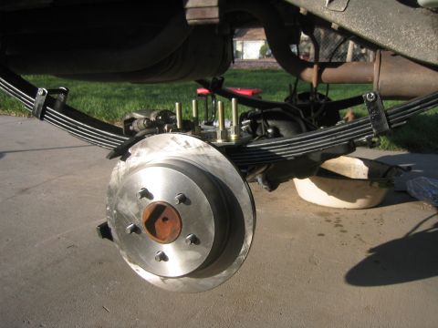 1997 Jeep Cherokee - Rear axle suspension work on a Jeep Cherokee, showing leaf springs and brake assembly.