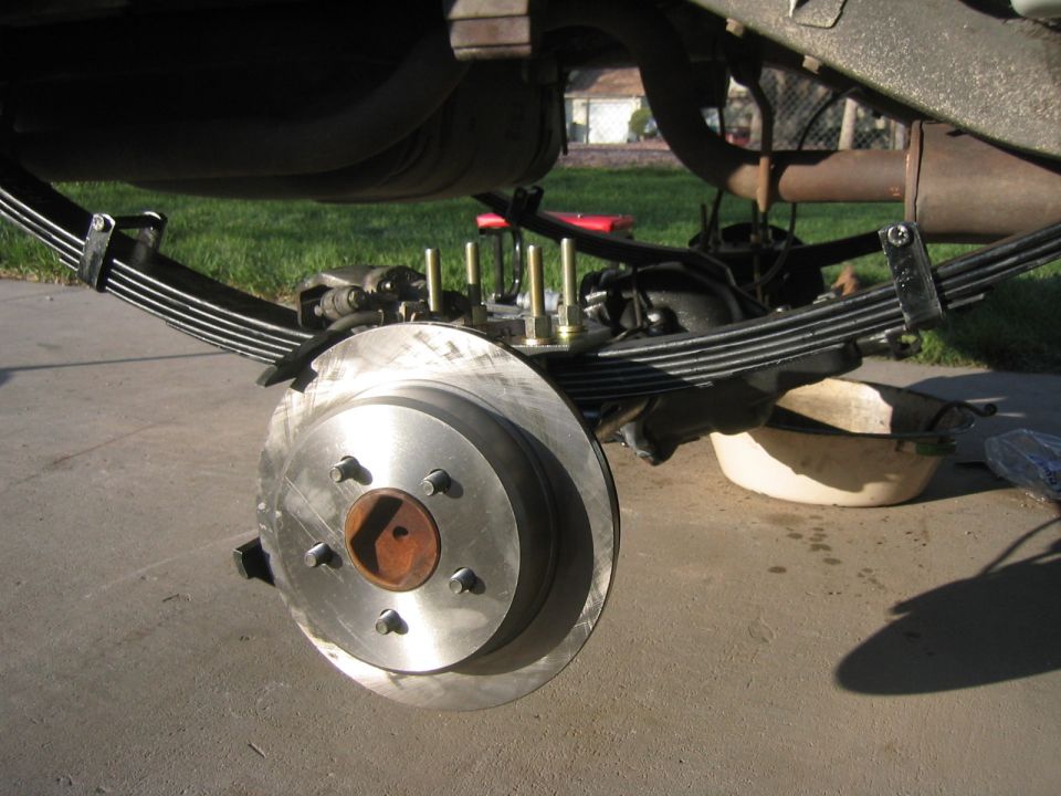 Jeep Cherokee rear axle with leaf springs and brake rotor during installation