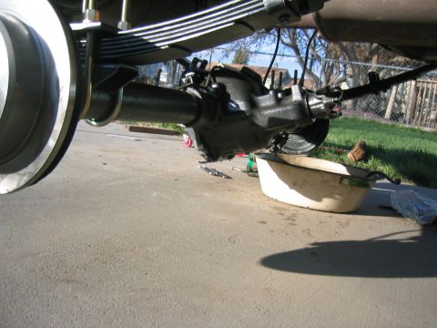 1997 Jeep Cherokee - The rear axle differential is shown during maintenance, with a drain pan positioned to catch fluids.