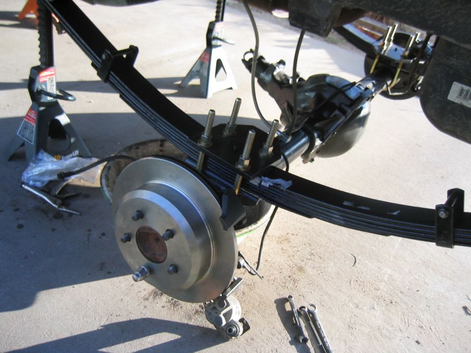 Rear axle assembly with leaf springs and brake rotor on jack stands