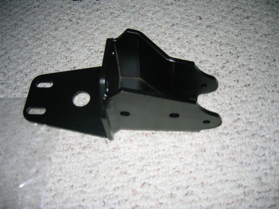 Black powder-coated fabricated steel suspension mounting bracket on carpet