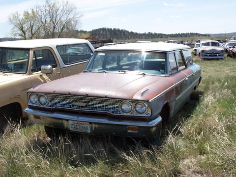 1968 Ford Coupe - This weathered 1963 Ford station wagon sits in a junkyard, its chrome grille and California license plate still visible despite the rust.