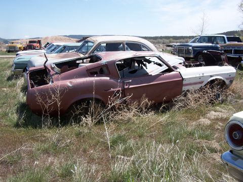 1968 Ford Coupe - Junkyard scene with multiple abandoned vehicles, including a damaged 1967-1968 Ford Mustang fastback.