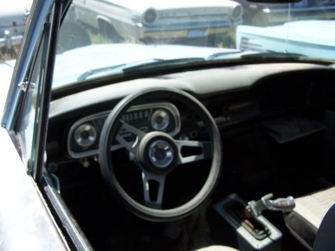 1968 Ford Coupe - Interior view of a 1968 Ford Coupe, its dashboard and steering wheel, with another vehicle visible in the background.